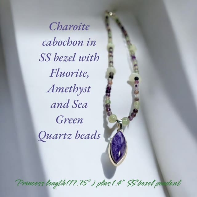 A necklace with purple and green beads on it.