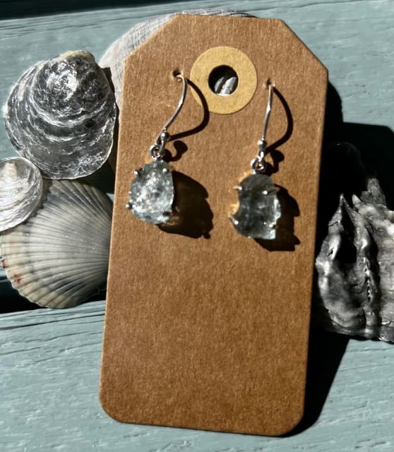 A pair of earrings sitting on top of a card.