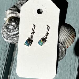 A pair of earrings sitting on top of a card.