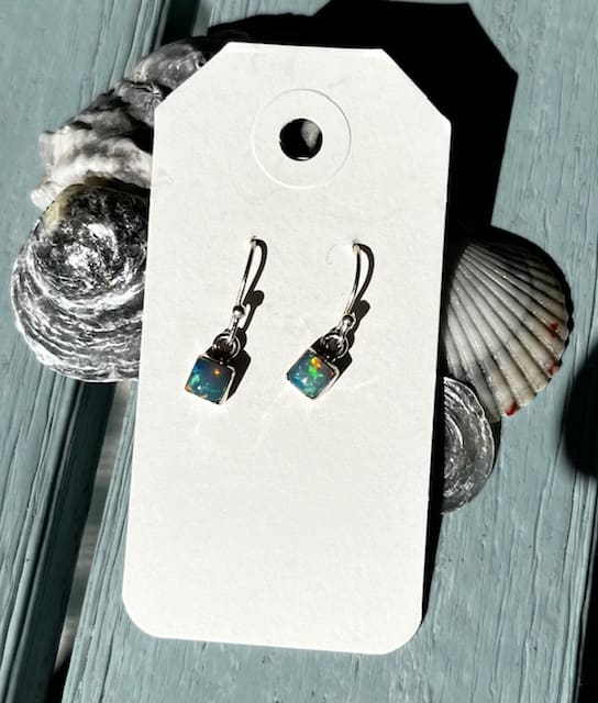 A pair of earrings sitting on top of a card.