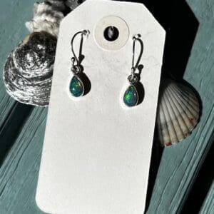 A pair of earrings sitting on top of a card.