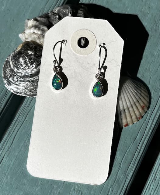 A pair of earrings sitting on top of a card.