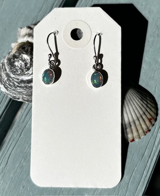 A pair of earrings sitting on top of a card board.