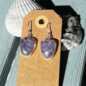 A pair of earrings sitting on top of a wooden table.