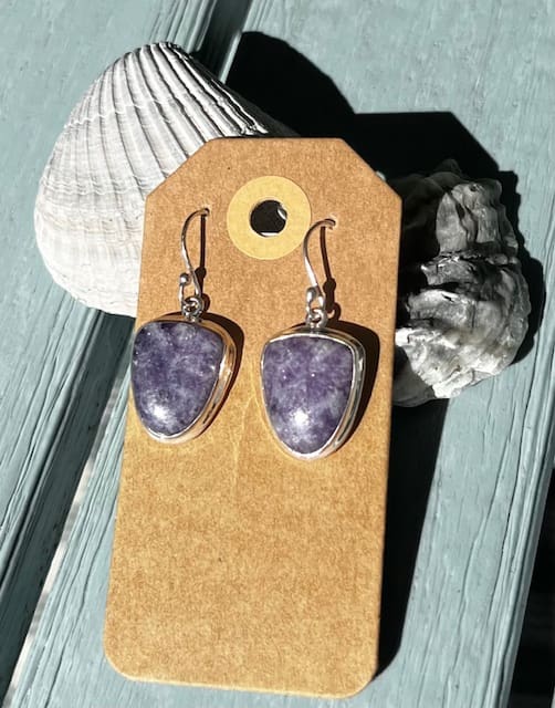 A pair of earrings sitting on top of a wooden table.