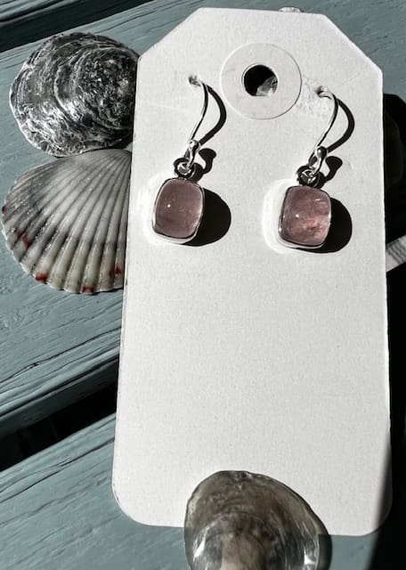 A pair of earrings sitting on top of a card.