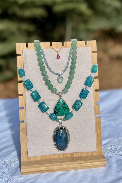 A display of three necklaces on a stand.