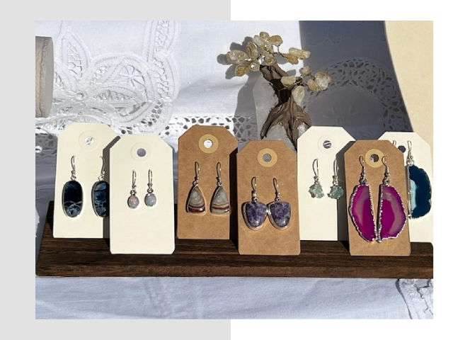 A row of earrings on display in cardboard tags.