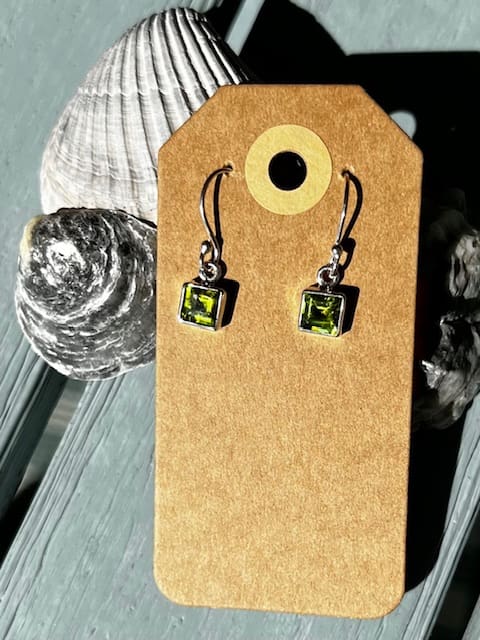 A pair of earrings sitting on top of a card.