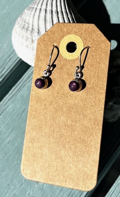 A pair of earrings hanging on top of a card.